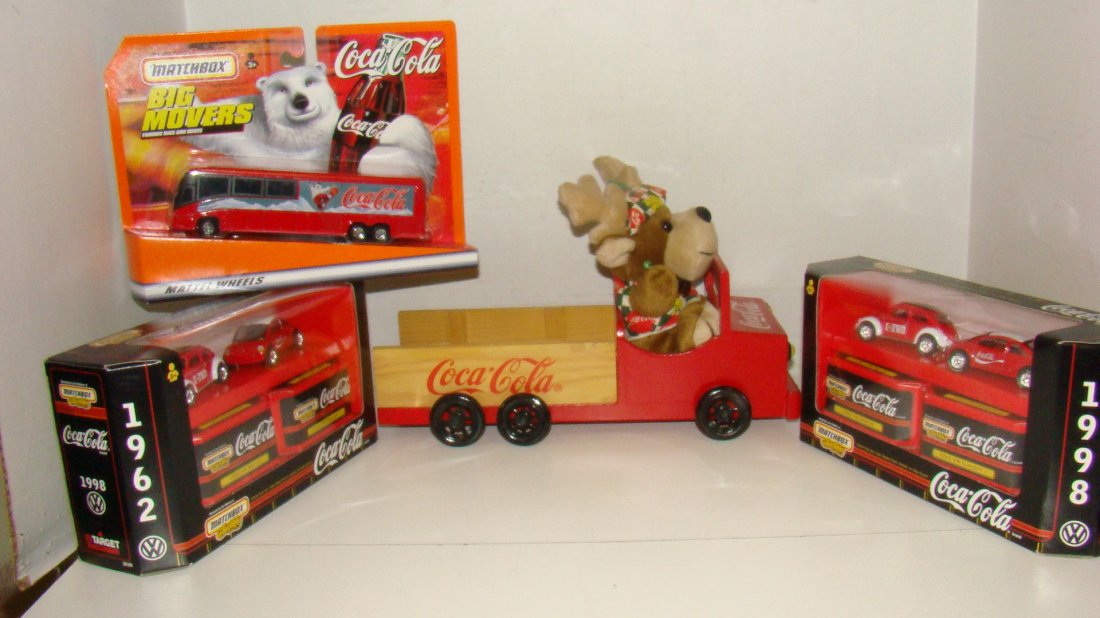 4 MATCHBOX COCA-COLA COLLECTIBLES: 2 NIB MATCHBOX DIE-CAST CAR SET - 1962 VW BEETLE AND COKE VW CONCEPT 1 CAR SET - NIB MATCHBOX COCA-COLA BIG MOVER DIE-CAST BUS AND A WOOD COCA-COLA CAR WITH REINDEER PLUSH TOY DRIVER