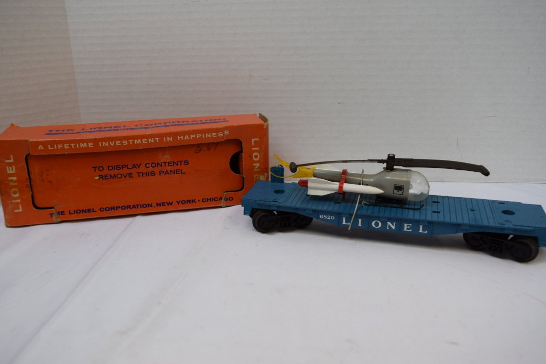 LIONEL FLAT CAR WITH HELICOPTER & MISSILES 6820: LIONEL 6820 - FLAT CAR WITH MISSILE TRANSPORT NAVY HELICOPTER IN ORIGINAL BOX. 2 MISSILES. BLUE FLAT CAR. BOX HAS BEEN OPENED AND IS DAMAGED.