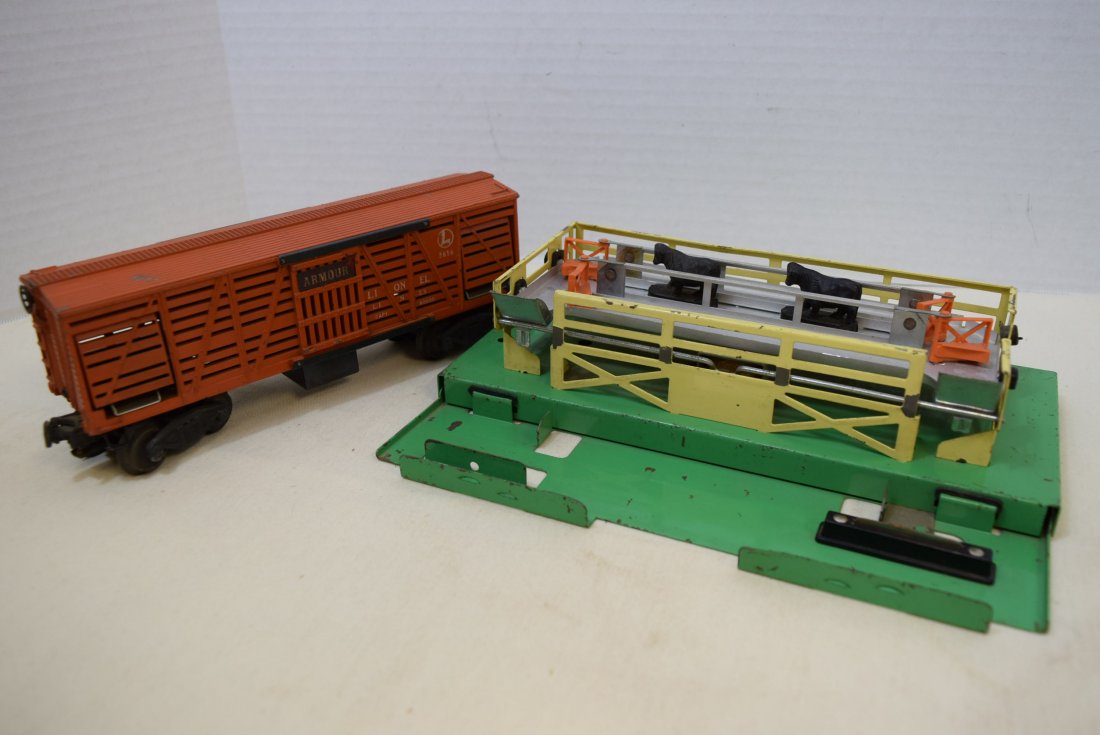 LIONEL STOCKYARD PLATFORM WITH OPERATING CATTLE CA: LIONEL STOCKYARD PLATFORM WITH OPERATING CATTLE CAR ARMOUR 3656. TWO EXTRA CATTLE. SOME PAINT WEAR ON THE PLATFORM. HAS FOUR GATES. WHEELS ON THE BOX CAR SHOW MINOR AGING AND WEAR. PAINT LOSS TO THE T