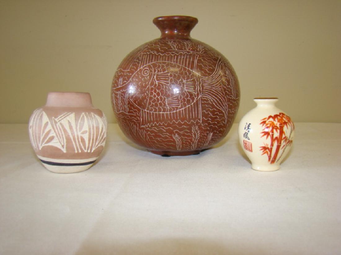 3 POTS/VASES: 3 POTS/VASES- 6.5''H BROWN CLAY VASE/POT WITH FISH DESIGN NO MARKINGS-APPROX 3''H VASE/POT TAN-BLACK-WHITE HAND CARVED DESIGN-MARKED SILAS NAVAJE- 2.5'' H ORIENTAL STYLE CABINET VASE -HAND PAINTED BAM