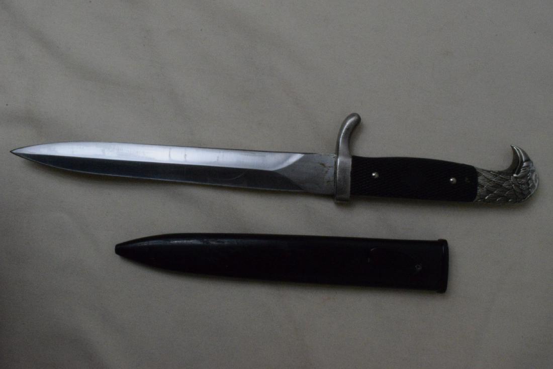 EAGLE HEAD DAGGER KNIFE: EAGLE HEAD DAGGER IN HARD SHEATH-SOME DISCOLORATION OF EAGLE METAL- STAINLESS STELL DOUBLE EDGED BLADE-UNKNOWN MAKER