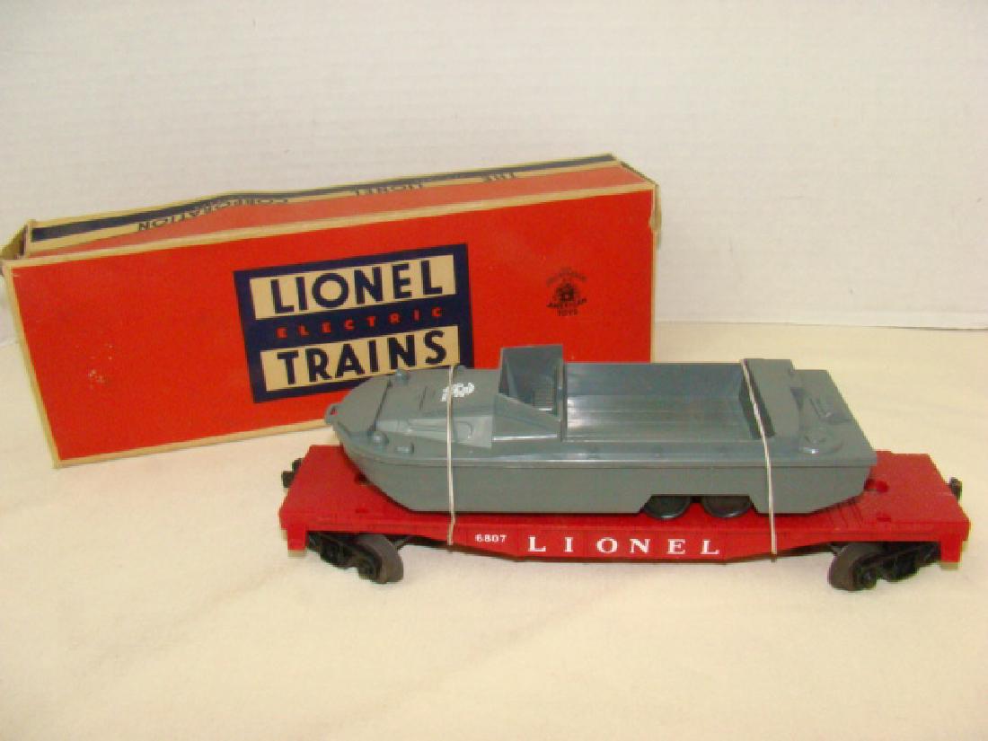 LIONEL TRAINS-FLAT CAR WITH MILITARY UNIT: LIONEL TRAINS-FLAT CAR WITH MILITARY UNIT IN BOX 6807-USMC PYRO BOAT- BOX DAMAGE-INK MARKS-FLAP TEARS-DENT