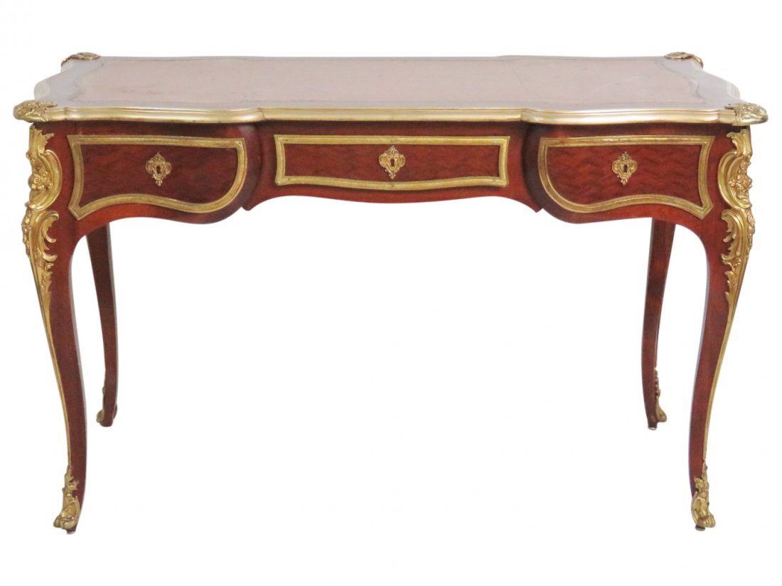 LOUIS XIV PARQUETRY INLAID LEATHERTOP DESK: Brown leather top. Brass decoration and mounts. Parquetry inlaid sides and drawers. 30"h x 49 1/2"w x 48"d