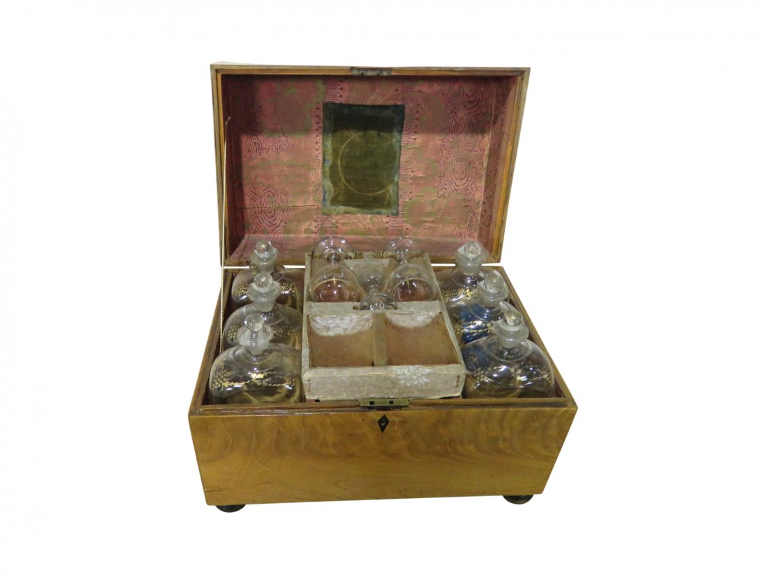 ANTIQUE TANTALUS: In wood box. Has six large bottles. Has one shot glass. Two smaller bottles. Has two wine glasses. Has four smaller bottles. 12" h x 17 1/8" w x 11 1/4" d.