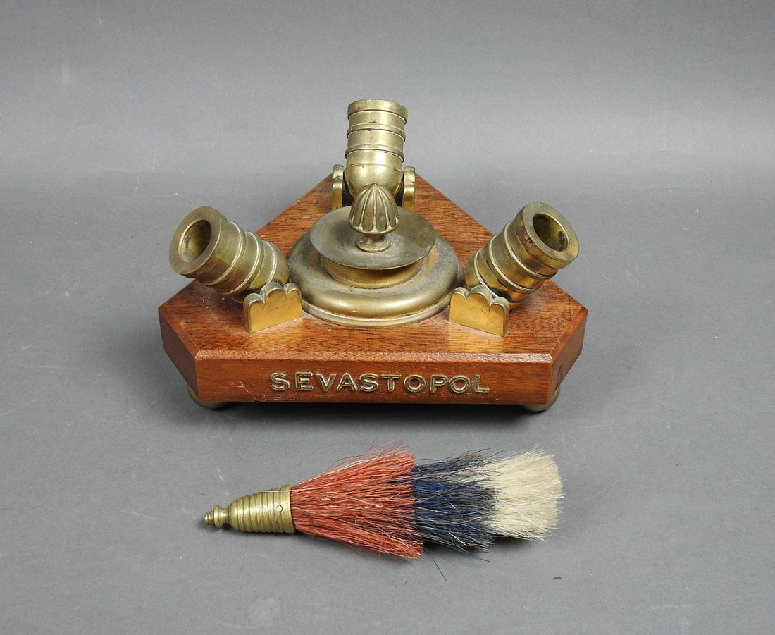 "SEVASTOPOL" TRIPLE MINI CANNON: Triple brass mini cannon mounted on a mahogany base with brass ball feet. Brass letters on the front "Sevastopol" along with a tri colored horse hair and brass military mount. Cannon: 5 1/2" h x 11" w