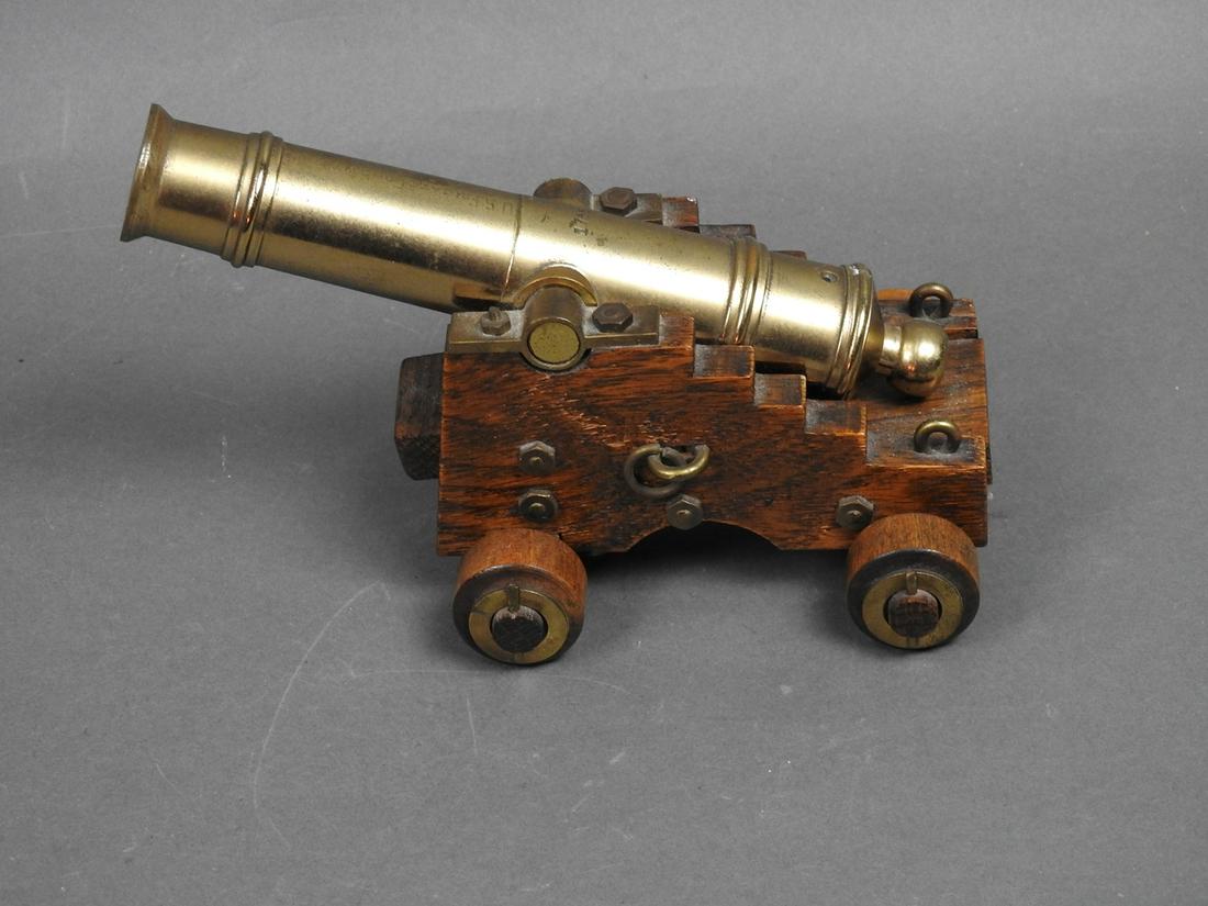 MINITURE SHIPS CANNON: Brass cannon with wooden bass. Functioning wooden wheels. Copy of U.S Frigate Constitution. Numbered 1755. 4 3/4" h x 4 1/2" w x 8 1/8" d
