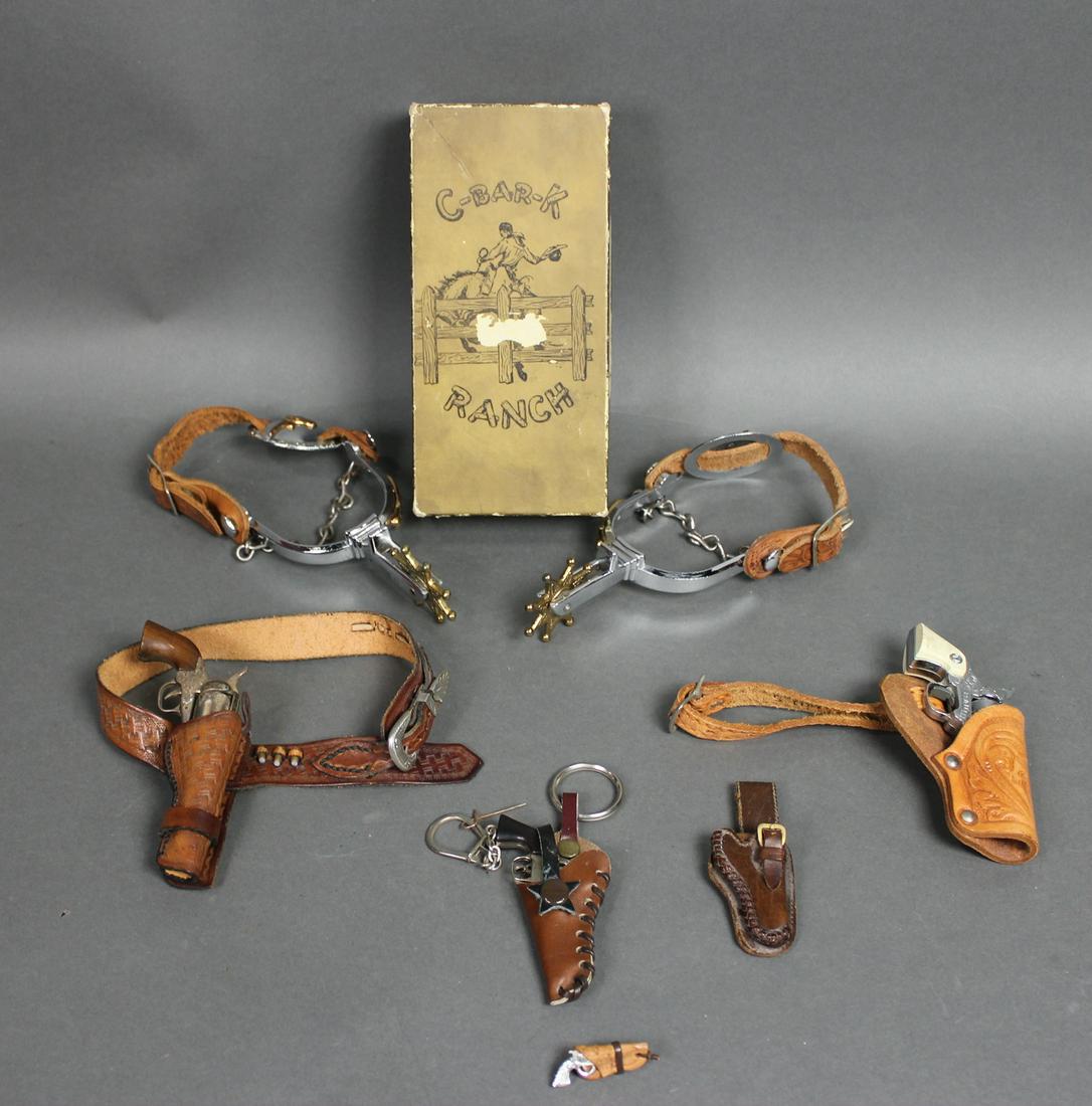 CHILD: C-Bar-K Ranch child's spurs w/Texas longhorn details in original box. Box 1 3/4" h x 7 3/4" w x 3 3/4" d. Lot also includes 3 miniature/toy guns, 4 holsters and a gun brooch.