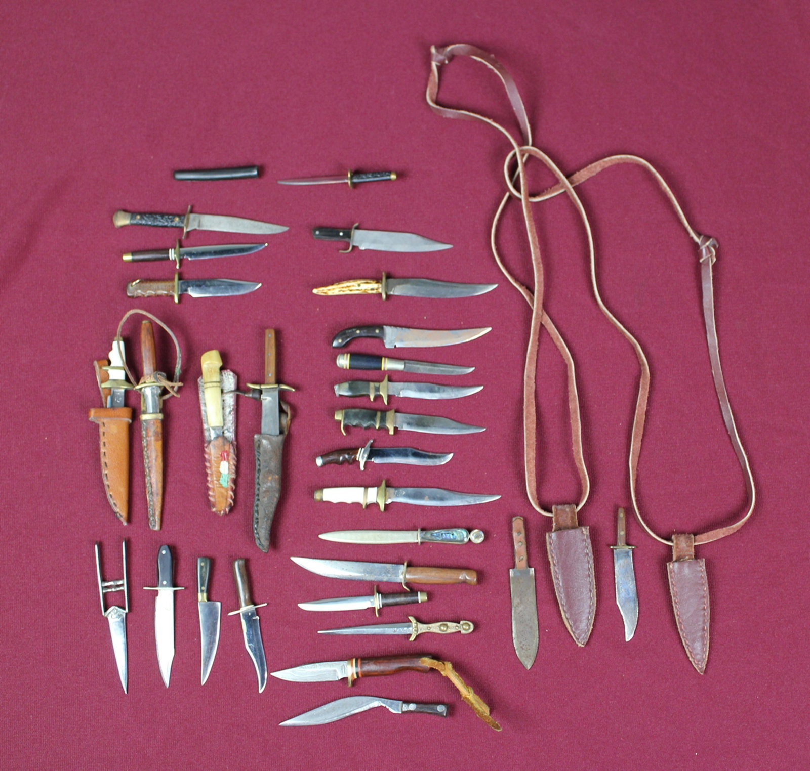 28 MINI KNIVES & WEAPONS: Assortment of weapons includes Damascus steel, bone, horn, brass & wood. 7 w/leather sheaths. Sizes range in length from 3 1/4" to 4 3/4"