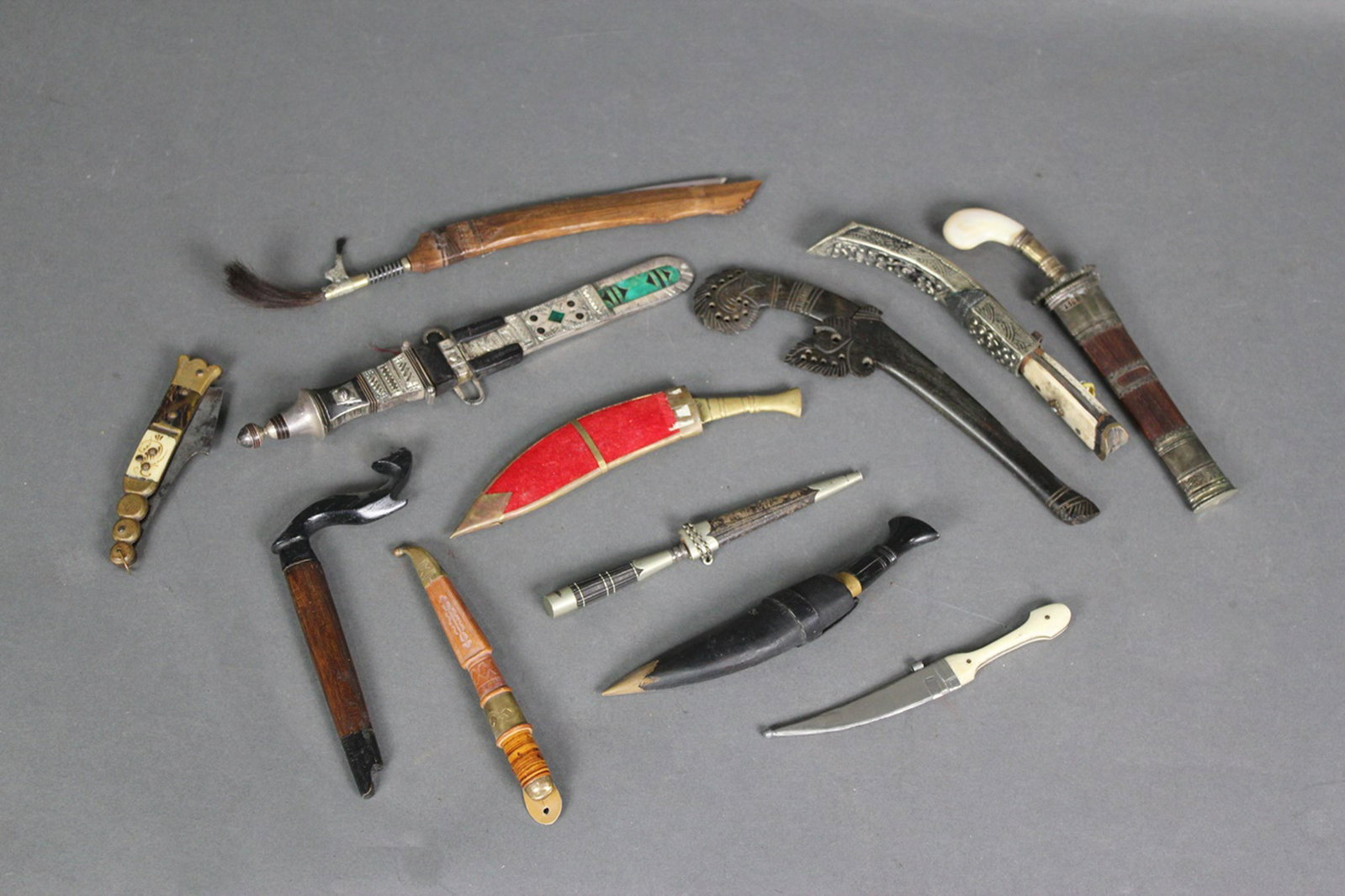 12 WEAPONS: DAGGERS KNIVES: All with sheaths. Wood, bone, mother of pearl. Lengths range from 4 3/8" to 8 5/8"