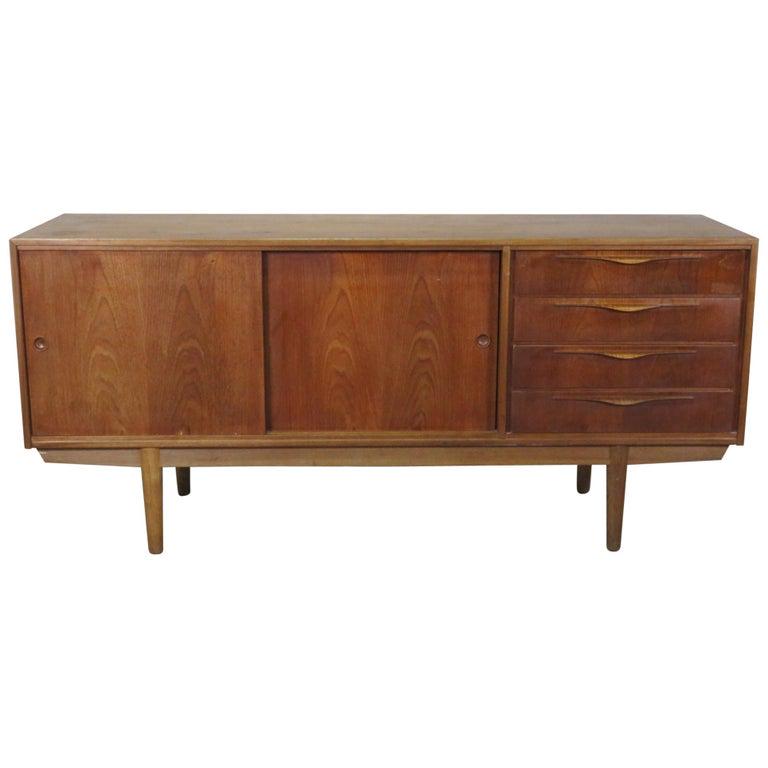 MID CENTURY MODERN DANISH TEAK CREDENZA: Teak. 2 sliding doors containing 3 shelves and 4 drawers. 33" h x 72 3/4" w x 19 1/2" d.