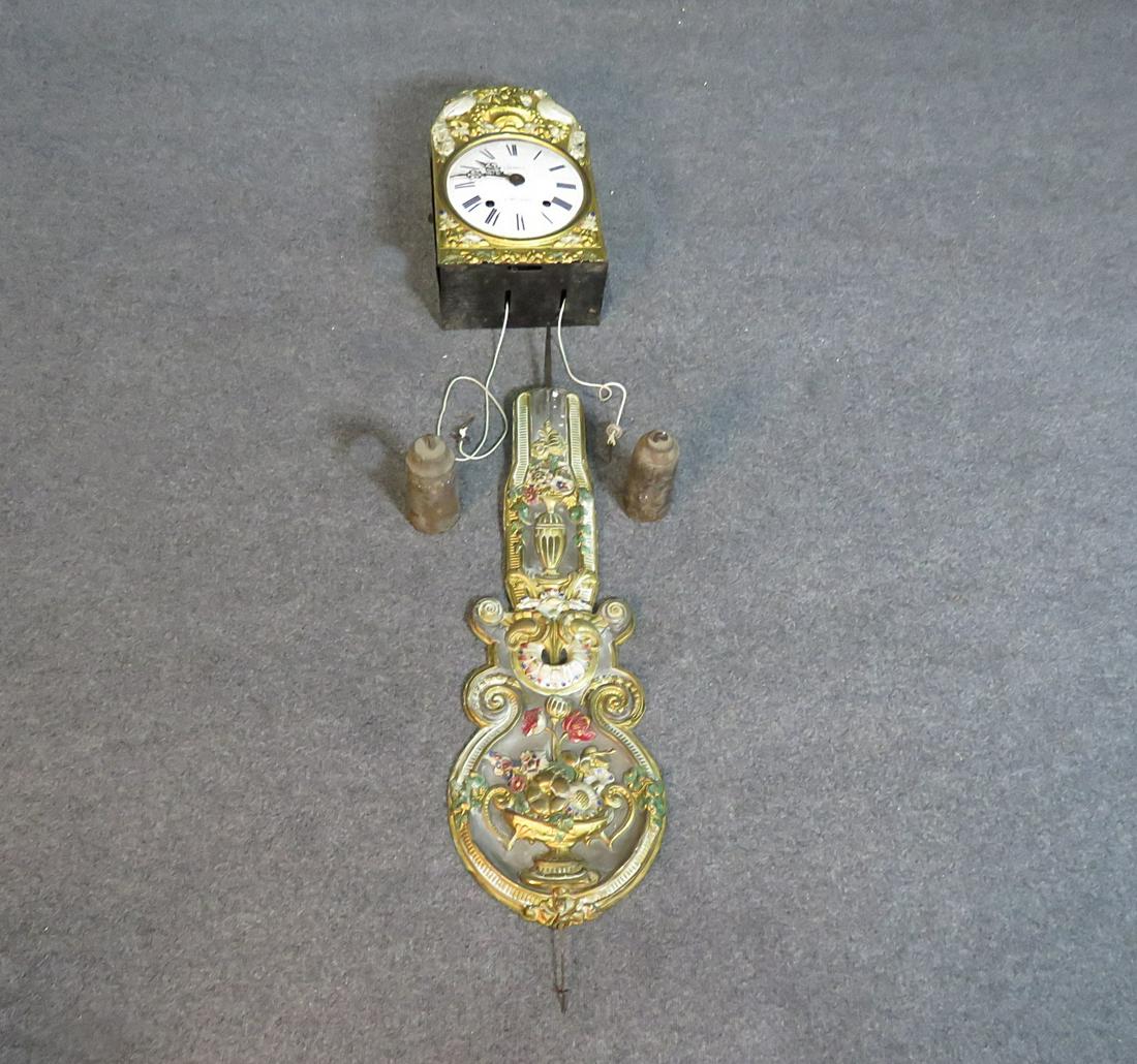 WAG ON WALL CLOCK: Carboy. A Montauban. Metal. Painted. With weights and pendulum. 4 pieces. Clock measures 18" h x 10 7/8" w x 5 3/4" d. Pendulum measures 41 7/8" h x 11 7/8" w.