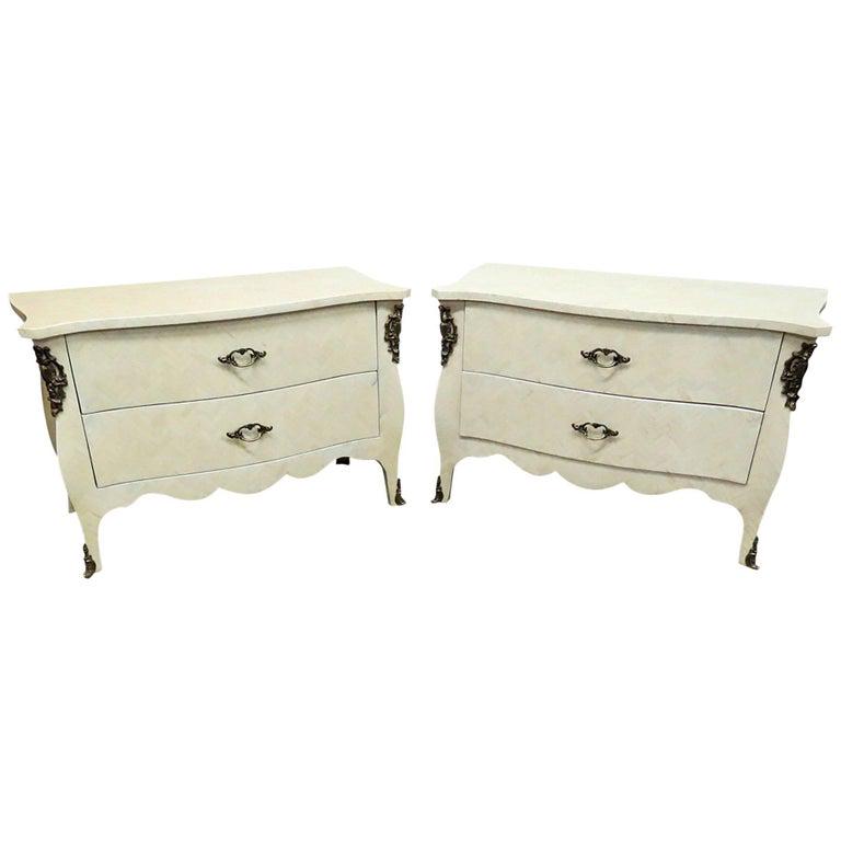 PR ENRIQUE GARCIA FAUX BONE VENEERED COMMODES: Pair of Enrique Garcia two drawer commodes with faux bone veneer and bronze accents. 24" h x 36 1/4" w x 17 3/4" d.