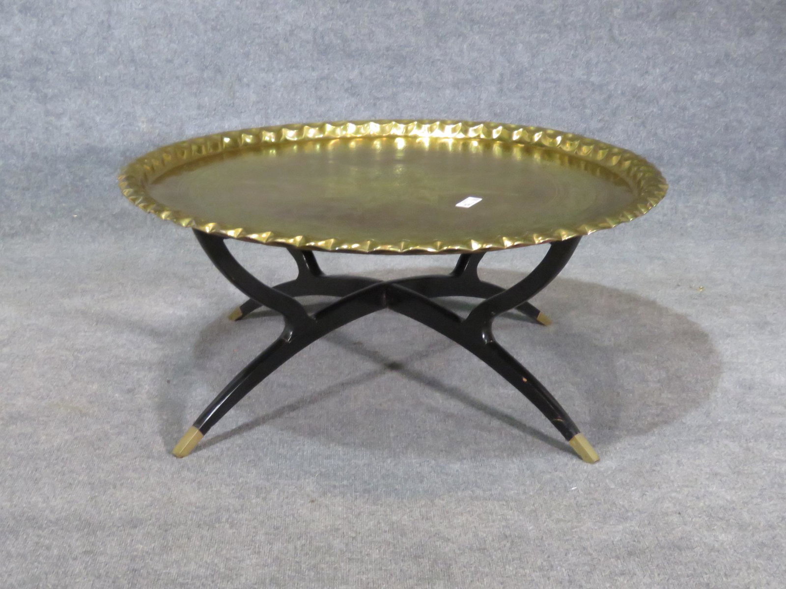 BRASS TRAY TOP TABLE: Brass tray top. Black legs with brass foot caps. 17 1/2" h x 39 1/4" diameter.