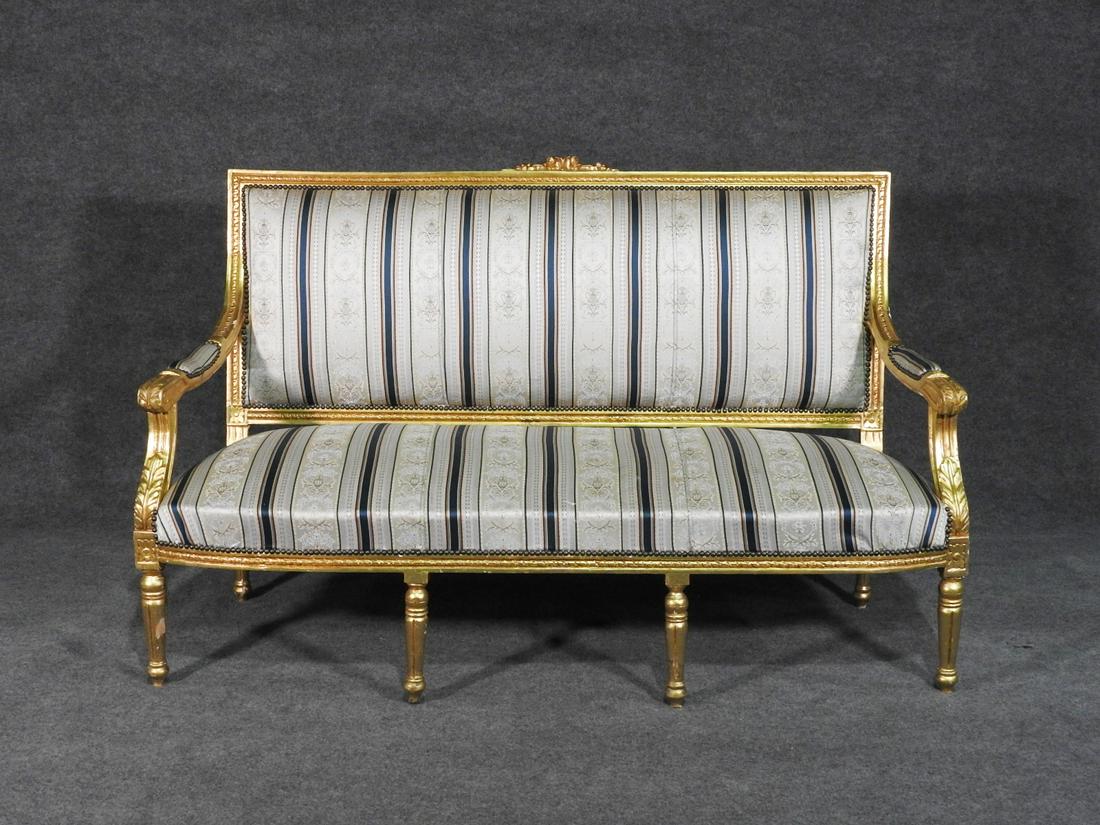 LOUIS XVI STYLE SETTEE: Gilt wood frame. Upholstered. Nail head trim. 41 1/4" h x 64 3/4" w x 27 1/2" d. Seat height 16".
