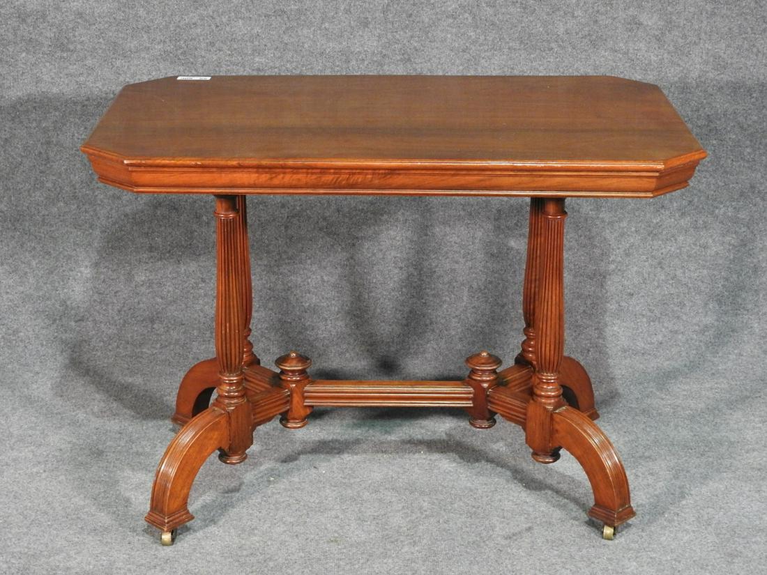 VICTORIAN CENTER TABLE: Walnut. On brass wheels. 30" h x 42" w x 26 1/2" d.