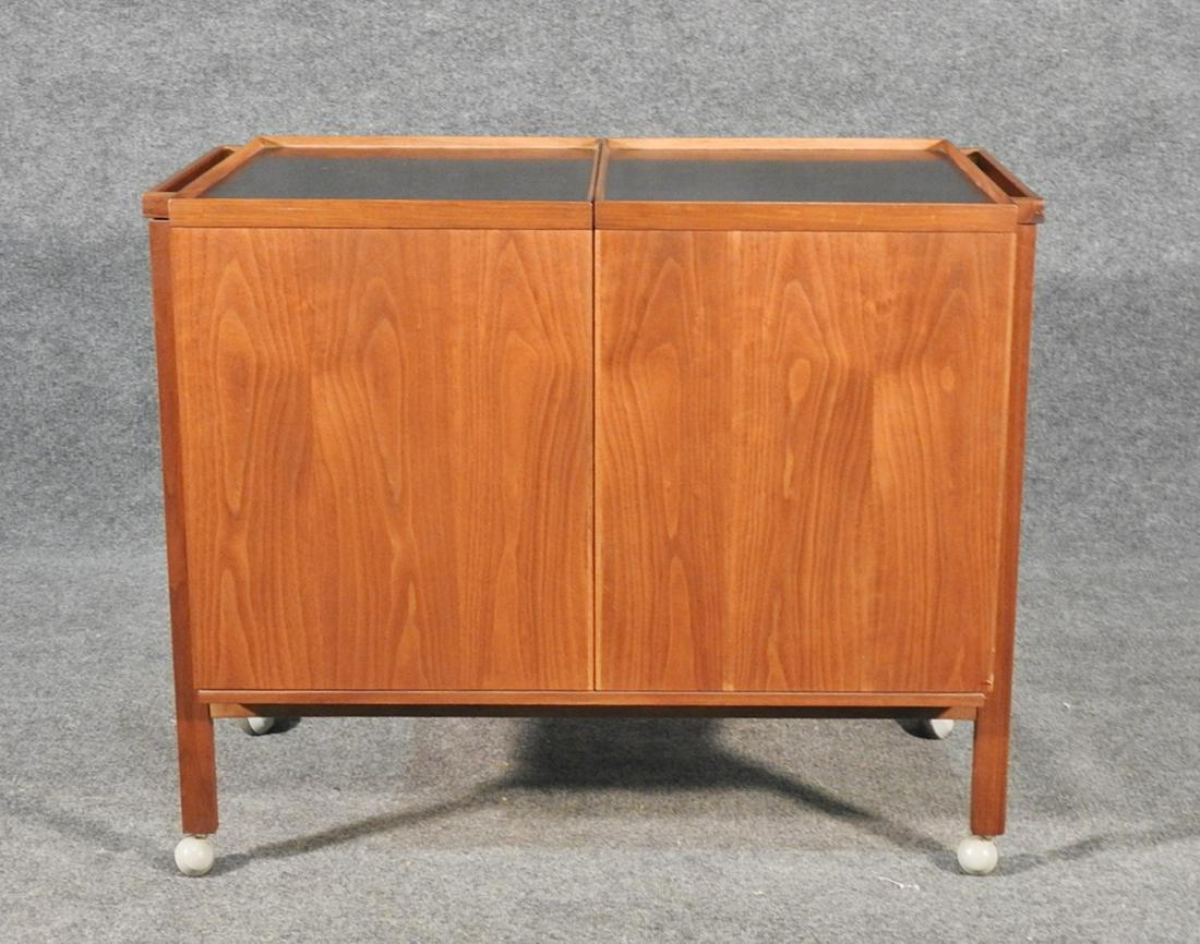 MID CENTURY MODERN DANISH BAR CART: Teak. On wheels. Two sliding doors when open contain glass shelf . 28 3/4" h x 35" w x 20" d.