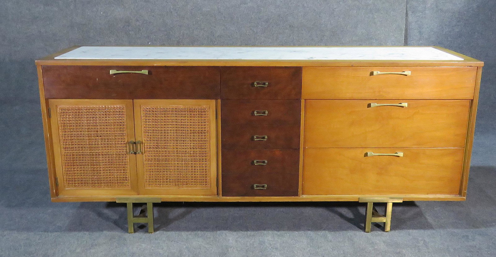 GROSFELD HOUSE MARBLE TOP INSERT DRESSER: Marble top insert. Walnut. 7 dovetailed drawers. 2 cane doors containing 2 dovetailed drawers. Metal legs and hardware. 33 1/4" h x 78" w x 21" d.