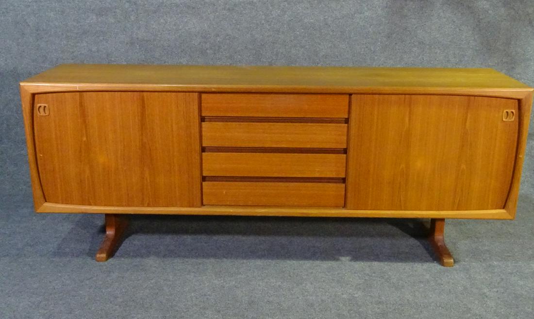 MODERN DANISH TEAK CREDENZA: Teak wood. Danish. Two sliding doors. Containing one shelve. Center has 4 drawers. 31 1/4"h. x 78 3/4"w. x 19 1/2"d.