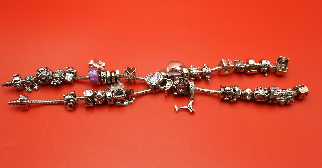 PAIR PANDORA STYLE BRACELETS: Sterling silver with multiple charms.