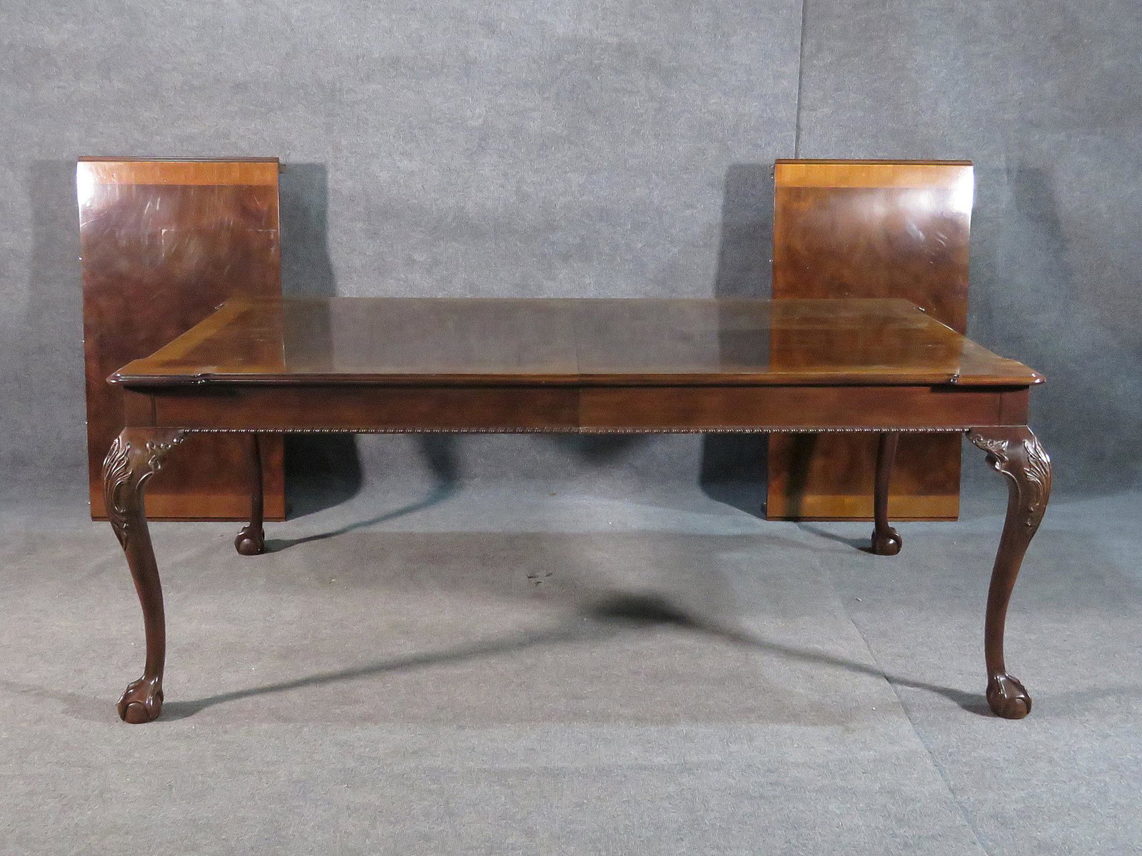 HENREDON DINING TABLE: Walnut. Carved legs. Claw feet. 2 pull out drawers. 2 leaves. 29 3/4" h x 77" h x 47" d. Leaves measure 24 1/8".