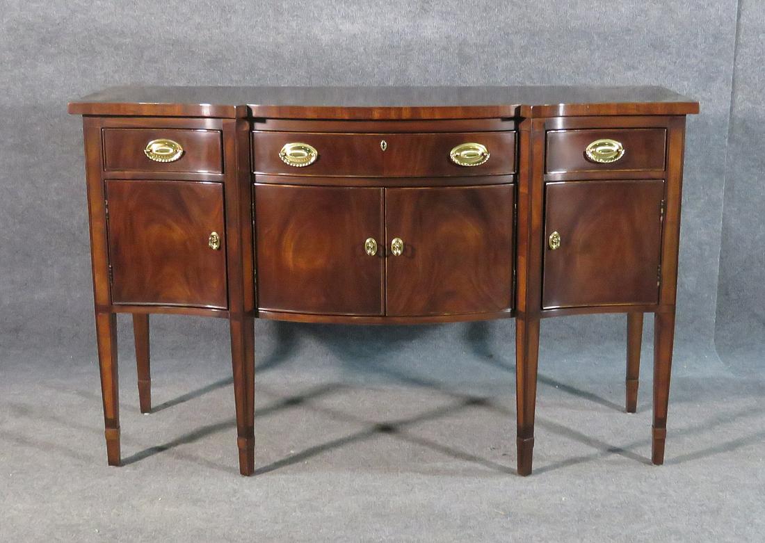 HENREDON SIDEBOARD: Walnut. 4 doors. 3 drawers. 2 pull out trays. Brass handles. 38" h x 60" w x 22 1/2 "d.