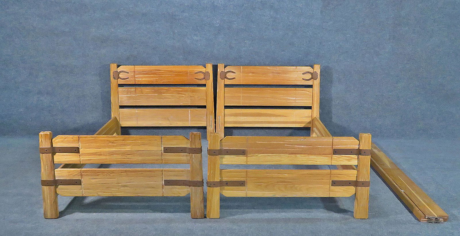 PAIR RANCH OAK TWIN BEDS: Oak frames. Twin size. Metal accents. Headboard and footboard. 32 1/8" h x 42 1/4" w x 79 3/4" d.