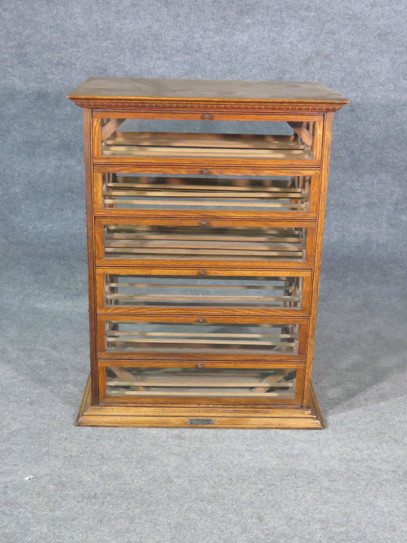 AN RUSSELL & SONS CO WINE CELLARETTE: Wood. 12 glass fold down doors. 2 glass sliding drawers. 37 7/8" h x 21 1/8" w x 18 1/4" d.