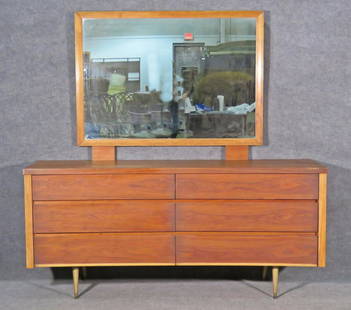 JOHNSON CARPER LONG DRESSER & MIRROR: Walnut. 6 dovetailed drawers. Brass feet. Dresser measures 32 3/4" h x 72" w x 21" d. Mirror measures 38 3/4" h x 48 3/8" w x 1 1/2".