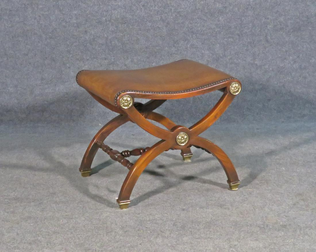 LEATHER X BENCH: Carved wood frame. Leather upholstery. Nail head trim. Metal accents and foot caps.18" h x 20 1/2" w x 17 1/2" d.