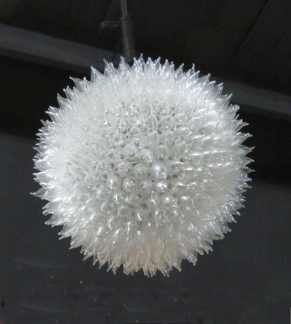 URCHIN CHANDELIER: Flamed tipped bulbs. Mounted to metal armature. Light comes from single bulb inside pendant. 20" h x 20" diameter.
