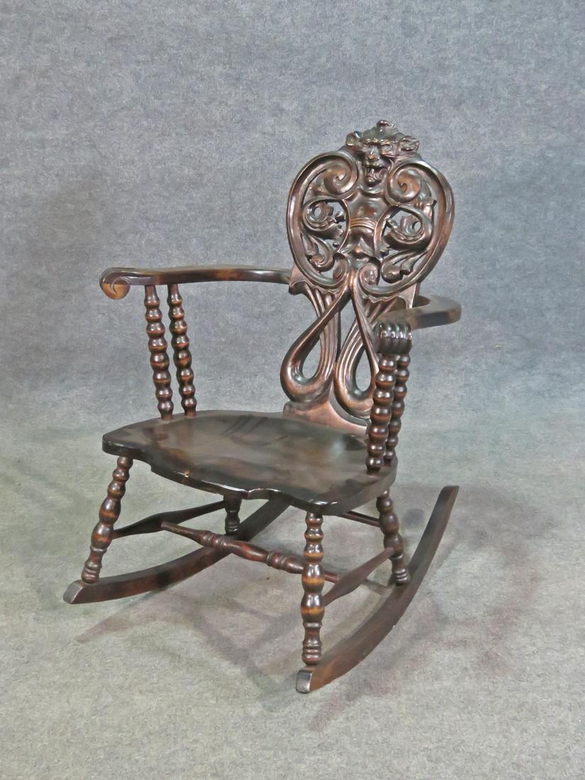 CARVED FIGURAL ROCKING CHAIR: Carved figural detail. 27 3/4" h x 27" w x 32" d. Seat height 16 1/2".