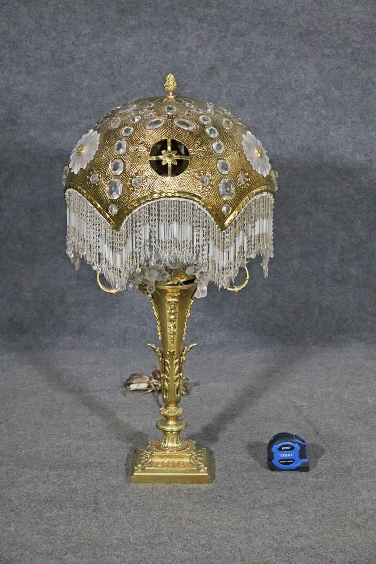 BRONZE BACCARAT LAMP W SHADE: Bronze base. Gilt shade. Bead fringe. Frosted flower accent. Embellished shade. Finial top. 37" h x 17 1/2" diameter.