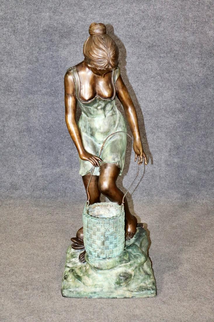 BRONZE FIGURAL FOUNTAIN: Bronze. Figure of girl with a basket and fish. 47" h x 14 1/2" w x 17 1/2" d.