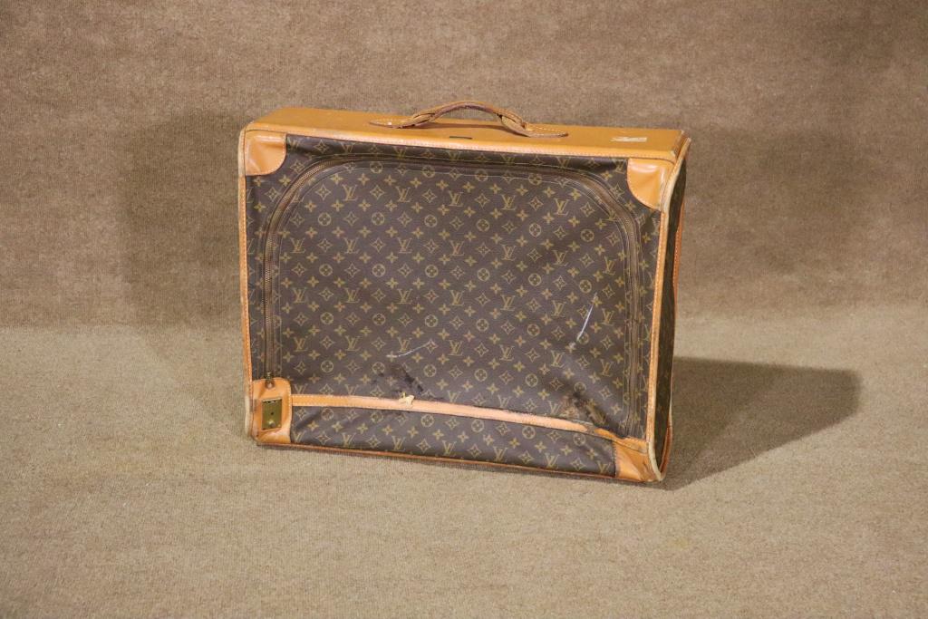 LOUIS VUITTON SUITCASE: Fabric. Leather. Louis Vuitton. Paris France. Manufactured by The French Co., USA under special license. 20" h x 25 3/4" w x 9 1/2" d.