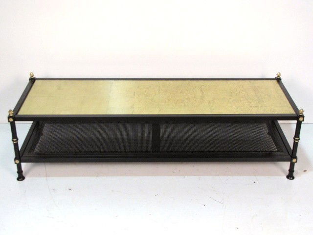 EBONIZED COFFEE TABLE w/ GILT GLASS TOP: Black painted metal. Gilt glass top. Caned shelf. Very good condition. 17"h. x 60 3/4"w. 20 3/4"d.