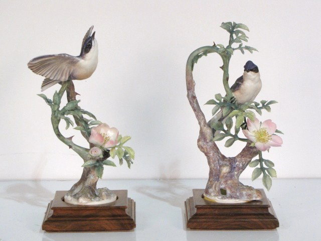 2 ROYAL WORCESTER DOROTHY DOUGHTY BIRDS: Lesser Whitethroat Sylvia. Very good condition with a broken leaf. Largest measures 11"h. including base. Smallest measures 10 3/4"h.including base.