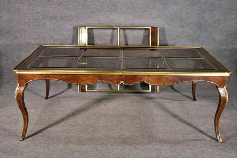 BERNHARD ROHNE FOR MASTERCRAFT BURL WALNUT & SMOKED GLASS TOP DINING TABLE: Burl walnut. Brass accents. 8 beveled smoked glass inserts on top. 4 beveled smoked glass inserts on leaf. 29 3/4" h x 82 1/2" w x 46" d. 1 - 45 5/8" leaf.