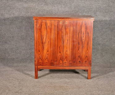 DANISH ROSEWOOD BAR CART: Danish. Rosewood. Flip up top. 2 doors containing shelves and brass cup holder racks on inside of doors. 32 3/4" h x 30 1/4" w (closed) x 60 3/4" w (open) x 16 3/8" d.