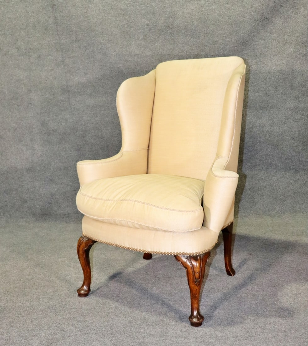QUEEN ANNE CARVED WALNUT WINGBACK FIRESIDE CHAIR: Walnut. Upholstered. Nail head trim. 46 3/4" h x 34 3/4" w x 33 1/4" d. Seat height 23 1/2".