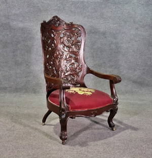 VICTORIAN MAHOGANY CARVED ARM CHAIR MANNER BELTER: Mahogany. Carved. On casters. Needlepoint seat. 41 1/4" h x 25" w x 29" d. Seat height 14 1/2".