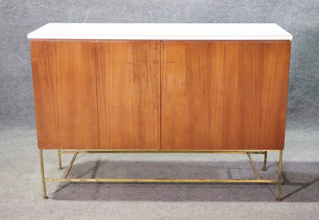PAUL MCCOBB FORMICA TOP CABINET: Formica top. Brass base. 2 doors. 37 1/4" h x 53 3/4" w x 19 1/4" d.