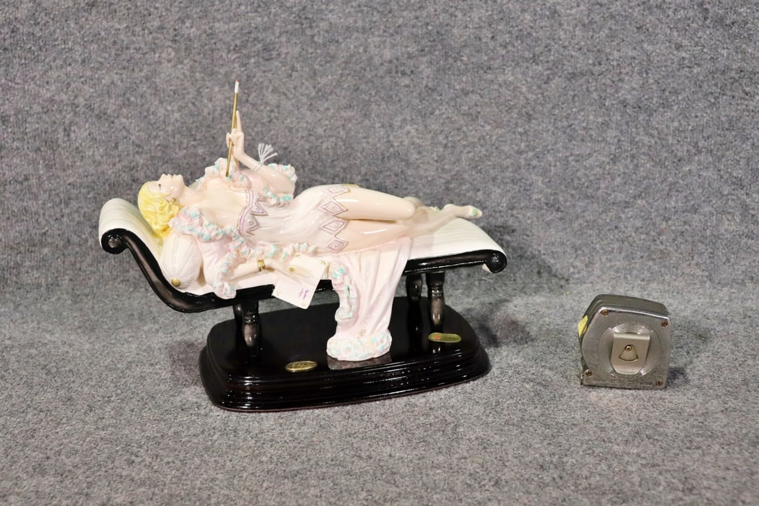 A. SANTINI SCULPTURE RECLINING WOMAN SMOKING CIGARETTE: Porcelain. Made in Italy. 11" h x 15 3/4" w x 8 7/8" d.