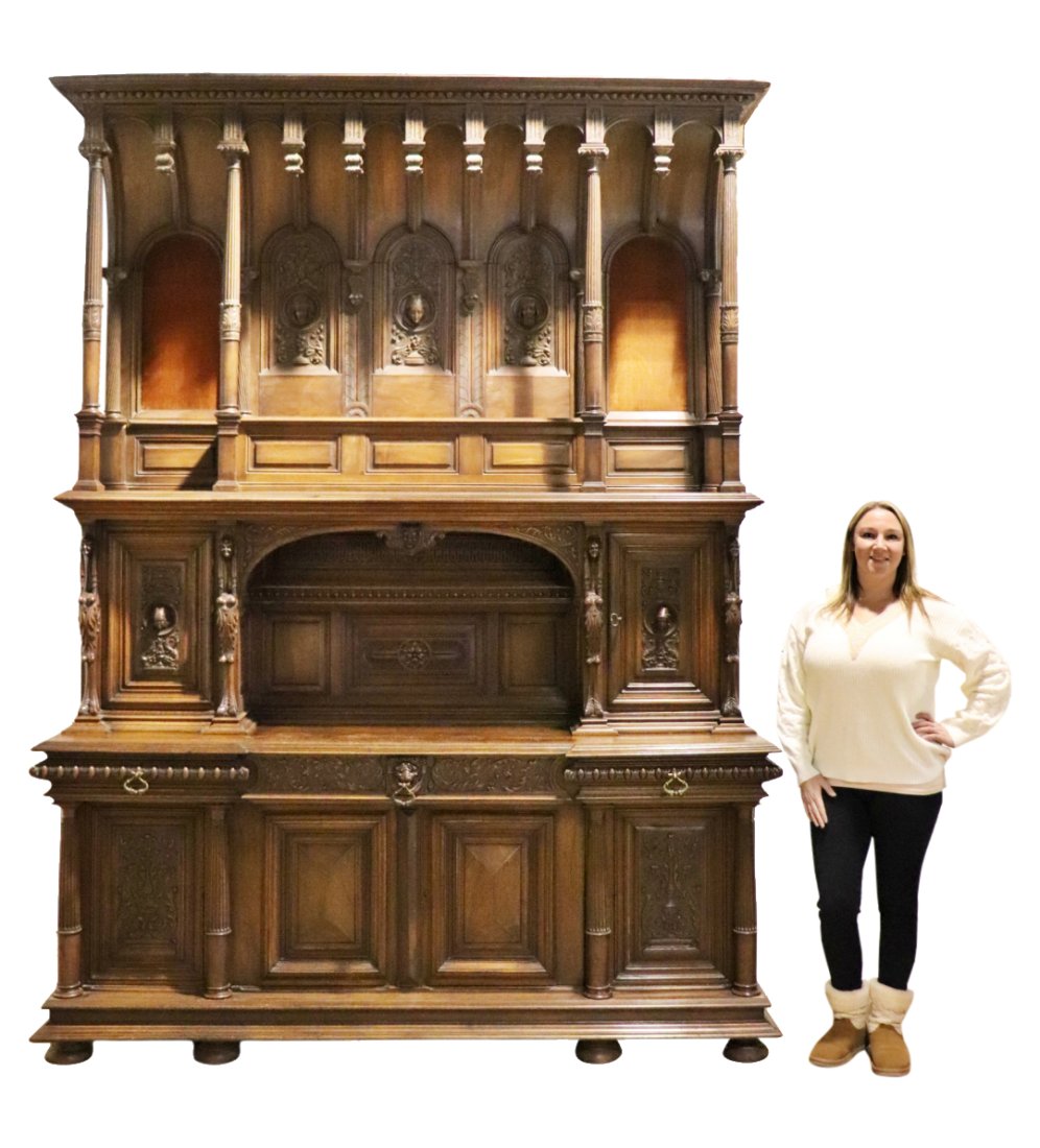 GOTHIC CARVED COURT CUPBOARD: Carved wood. Figural. Center has 2 doors containing 1 shelf each. Gallery shelf in middle. 3 dovetailed drawers. 4 doors on bottom containing 1 shelf each. 115" h x 87 1/2" w x 25 1/4" d.