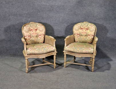 PAIR LOUIS XVI STYLE CANE ARM CHAIRS: Distressed. Cane. Carved. Upholstered arm rests. Removable upholstered cushion. Upholstered cushions on backs attached. 36" h x 26" w x 30" d. Seat height 15".