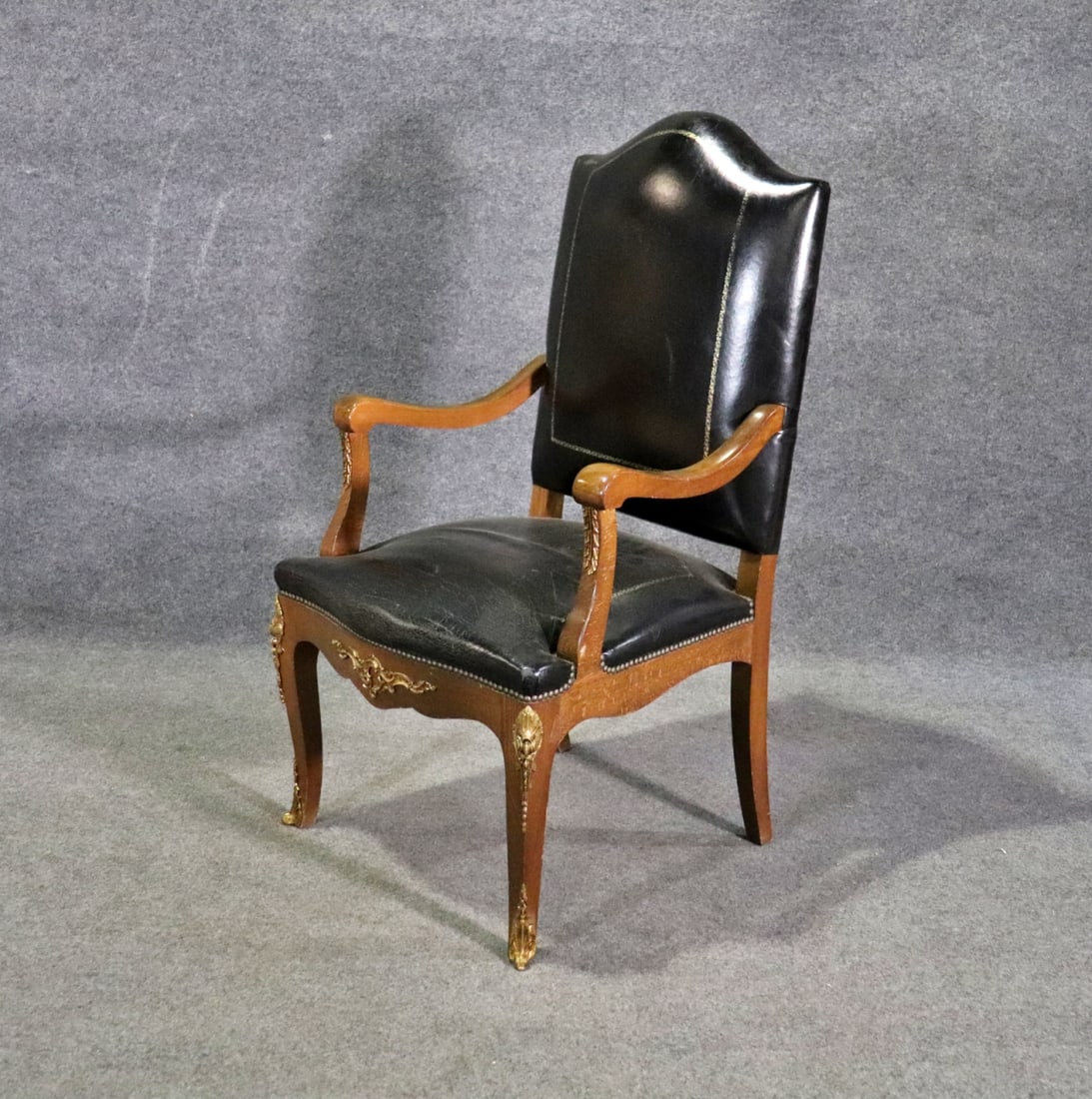 LOUIS XV STYLE LEATHER ARM CHAIR: Walnut frame. Leather upholstery. Nail head trim. Bronze accents. 46 1/4" h x 25 1/2" w x 27 1/2" d. Seat height 20 1/2".