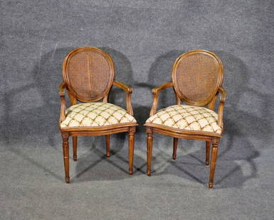 PAIR LOUIS XVI STYLE CANE BACK ARM CHAIRS: Carved wood frames. Cane back. Upholstered seats. 37 1/4" h x 22 1/2" w x 23 1/2" d. Seat height 20 1/2".