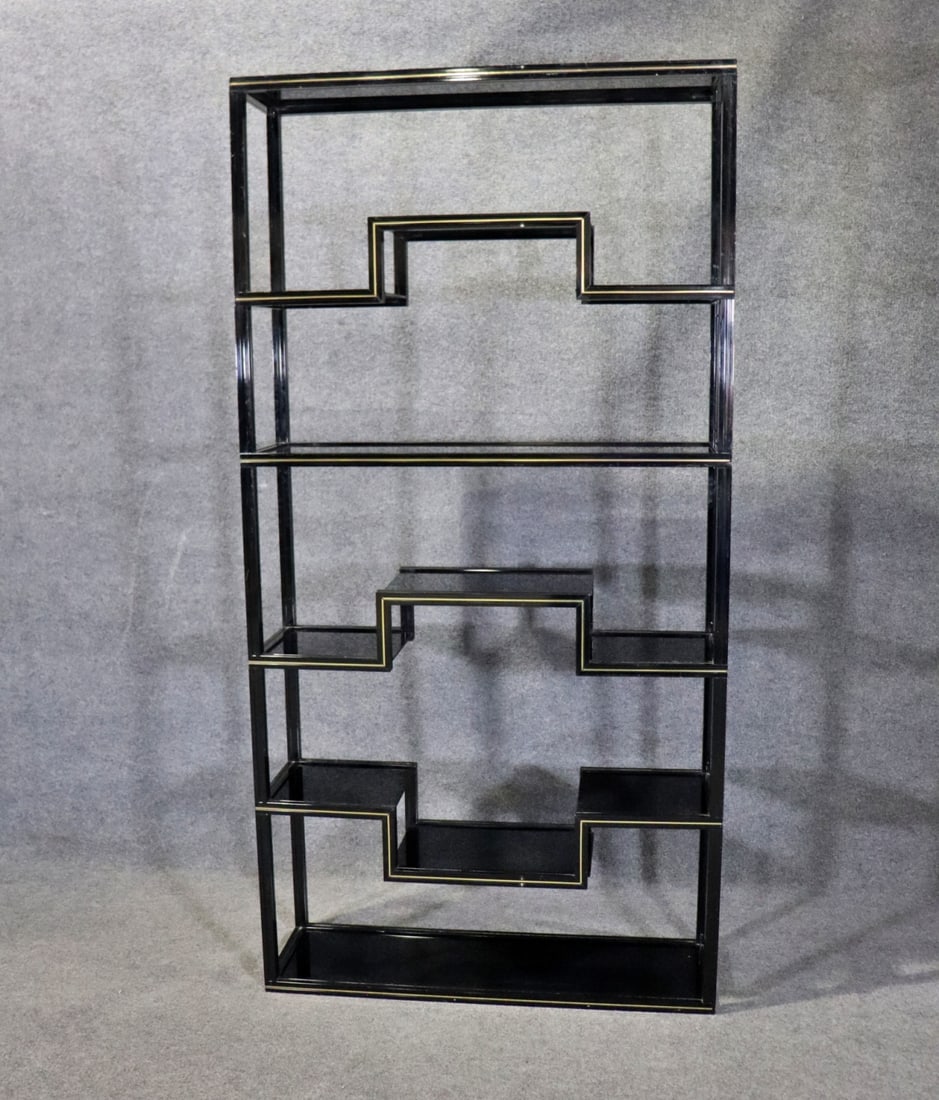 NEOCLASSICAL BLACK LACQUERED ETAGERE AFTER PIERRE VANDEL: Circa 1970's. Black lacquered aluminum. Gold foil accents. 12 smoke glass shelves. 77 5/8" h x 39 1/2" w x 11 7/8" d.