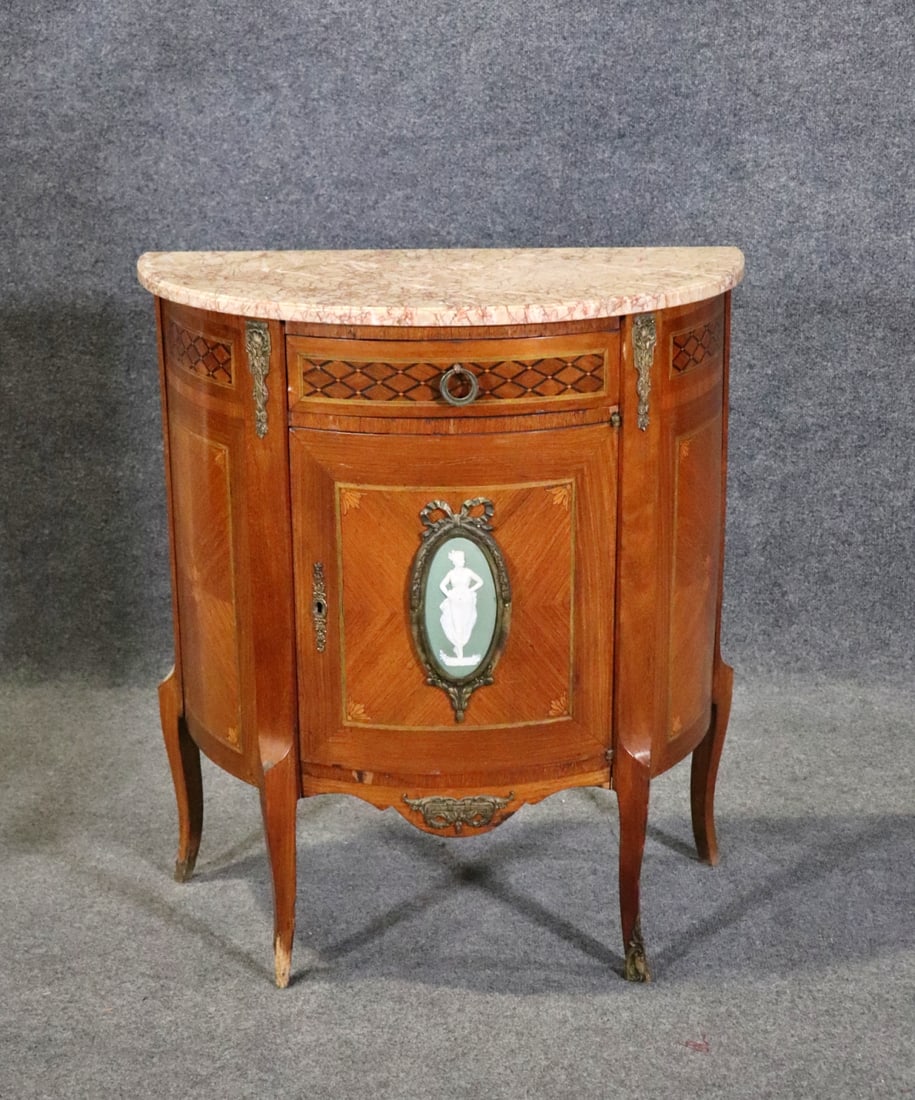 FRENCH MARBLE TOP ONE DOOR COMMODE: Marble top. Porcelain plaque insert. Bronze accents and hardware. Inlaid. 1 door containing 1 shelf. 1 dovetailed drawer. 31 1/8" h x 28" w x 15 3/8" d.