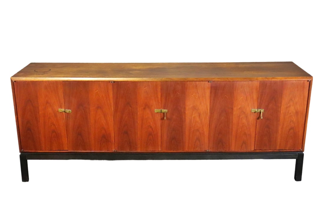 JACK CARTWRIGHT FOR FOUNDERS WALNUT CABINET: Walnut. 6 doors. 2 doors on each side contain 1 shelf. Center two doors contain 3 dovetailed drawers. Brass hardware. 30 1/4" h x 77 3/8" w x 18" d.