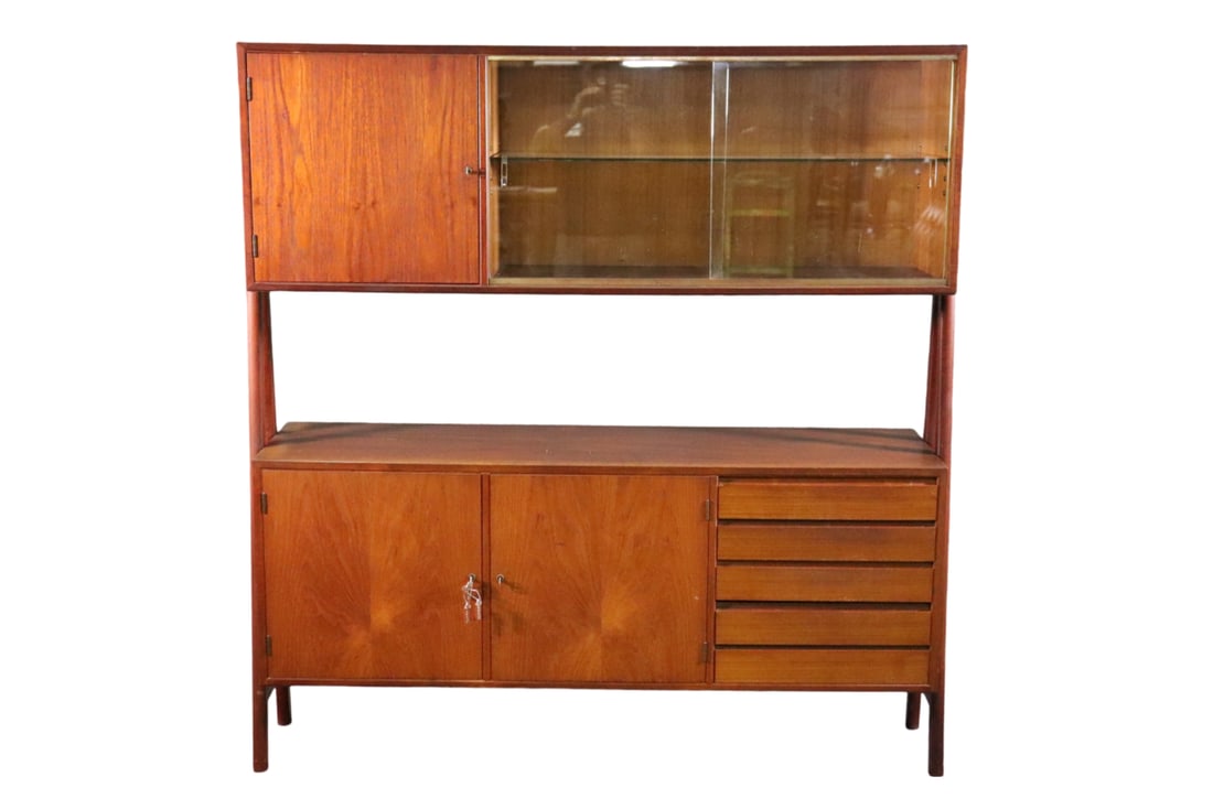 DANISH TEAK SIDEBOARD: Danish. Teak. Top has 2 glass sliding doors containing 1 glass shelf. 1 wood door containing 1 shelf. Bottom has 2 wood doors containing 1 shelf each and 4 drawers. 60 3/4" h x 58 5/8" w x 15 1/4" d.